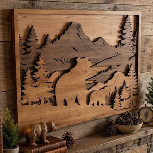 May include: Wooden wall art featuring a mountain scene with bears and trees. The artwork is framed and displayed above a fireplace. Decorative items include books, a bear figurine, and a small clock.