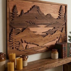 May include: A large wooden wall art piece showing a mountain landscape with trees and a lake. The artwork is above a rustic wooden console table with candles, books, and pottery. The room has a cosy, cabin-like atmosphere.