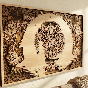 May include: Wooden wall art featuring a layered design with a central mandala and floral patterns. The artwork is framed in a natural wood tone, creating a warm, inviting aesthetic. The intricate details and light and dark wood tones add depth and visual interest to the piece.