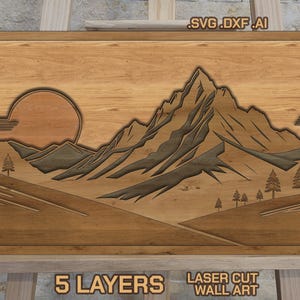 May include: Wooden wall art depicting a mountain scene with a setting sun. The laser-cut design has five layers, giving a 3D appearance. The text "SVG .DXF .AI" is at the top, and "5 LAYERS LASER CUT WALL ART" is at the bottom.