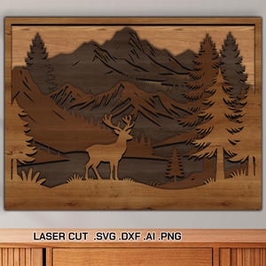 May include: Wooden laser-cut wall art depicting a mountain landscape with a deer, trees, and mountains. The artwork is framed in a rectangular shape and features a layered design with varying shades of brown. The text "LASER CUT .SVG .DXF .AI .PNG" is at the bottom.