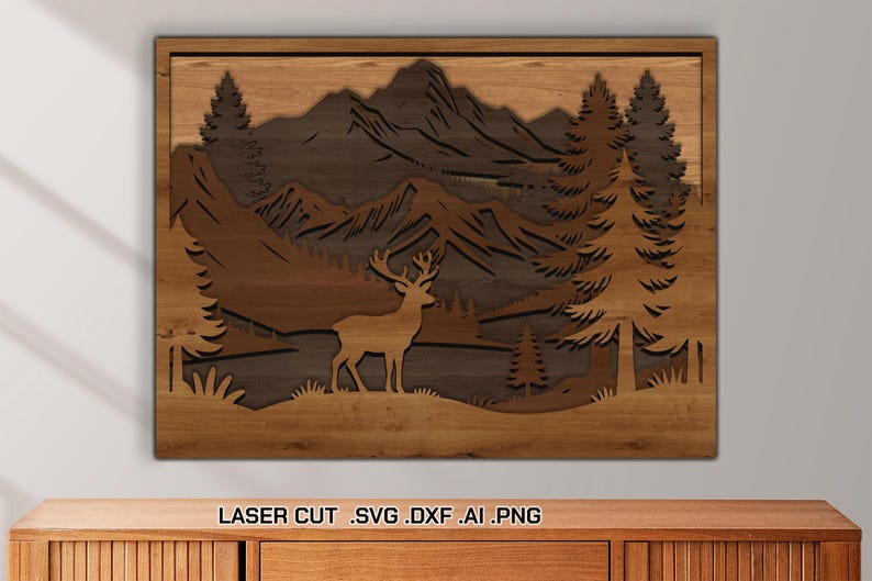 May include: Wooden laser-cut wall art depicting a mountain landscape with a deer, trees, and mountains. The artwork is framed in a rectangular shape and features a layered design with varying shades of brown. The text "LASER CUT .SVG .DXF .AI .PNG" is at the bottom.