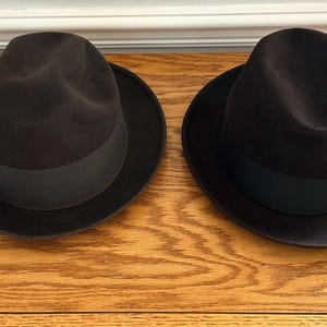 May include: A white ceramic mug with a black handle and the text "But First, Coffee" in a handwritten style. The mug is on a white surface. The mug is 4 inches tall.