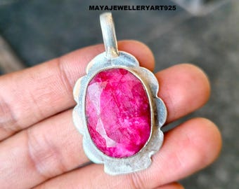 Könnte beinhalten: Silberanhänger mit einem großen, oval geschliffenen Rubin-Edelstein. Der Rubin hat eine leuchtend rosa-rote Farbe und ist in einen silbernen, wellenförmigen Rahmen gefasst. Der Anhänger hat eine kleine Schlaufe. Text auf dem Bild: MAYAJEWELLERYART925.