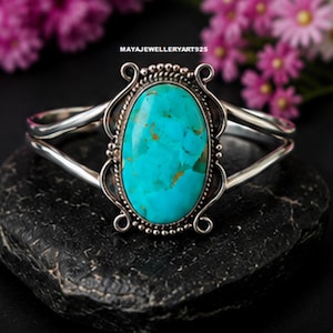 May include: A silver cuff bracelet featuring a large, oval-shaped turquoise stone with brown matrix inclusions. The setting includes decorative twisted wire and beaded metalwork details. The text MAYAJEWELLERYART925 is visible above the bracelet.