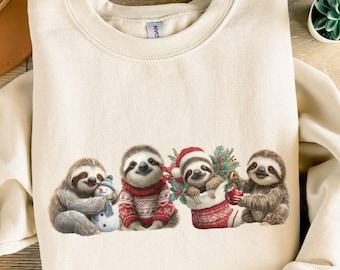 May include: A sand-colored sweatshirt featuring a festive sloth design. Four sloths are depicted, one holding a snowman, another wearing a red sweater, a third in a Christmas stocking, and the last holding a candy cane. The design is printed on a soft, casual sweatshirt.
