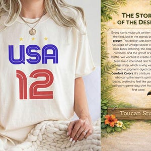 K&ouml;nnte beinhalten: Cremefarbenes T-Shirt mit "USA 12" in blauen und roten Blockbuchstaben. Das Shirt-Design enth&auml;lt drei kleine gelbe Sterne &uuml;ber dem Wort "USA". Der Text "THE STORY OF THE DESIGN" ist auf der rechten Seite des Bildes zu sehen.