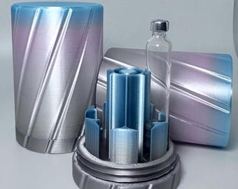 May include: A cylindrical container with a blue and purple gradient finish and diagonal grooves. The container is open, revealing a blue internal structure with vertical slots designed to hold a single clear glass vial with a silver metal cap.