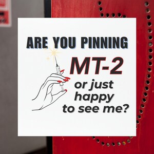 Könnte beinhalten: Weißes quadratisches Schild mit schwarzem Text: „ARE YOU PINNING MT-2 or just happy to see me?“ Eine Hand mit roten Nägeln hält eine Spritze. Der Hintergrund ist rot.