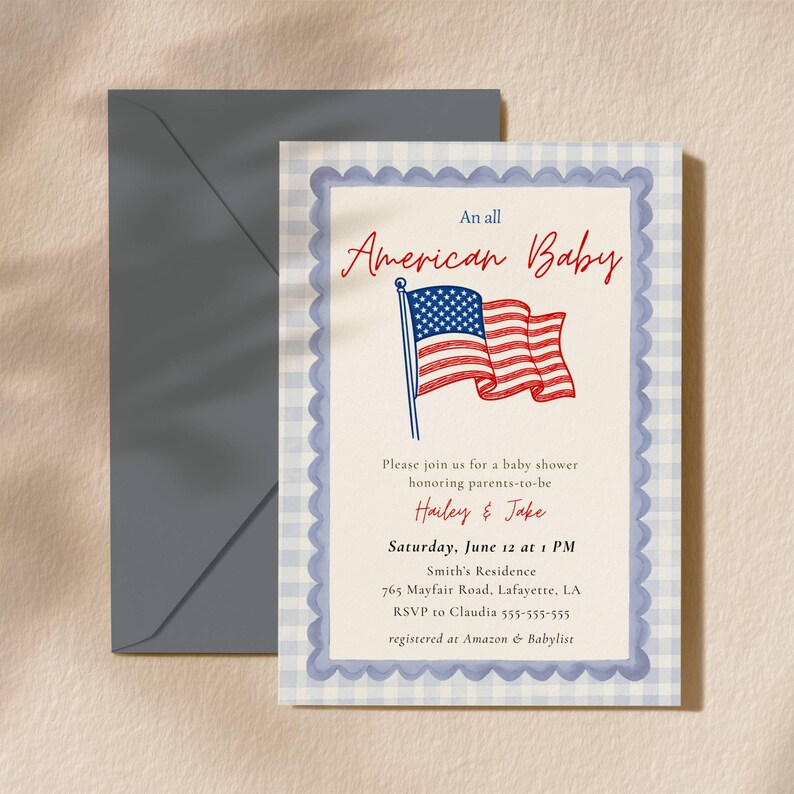 An All American Baby shower invitation displayed with a grey envelope on a warm beige background, featuring a hand-illustrated waving American flag, red cursive "American Baby" heading, blue scallop inner border, and blue gingham outer border