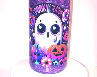 May include: A purple glitter tumbler with a matching lid and straw. The tumbler features a Halloween-themed design with a cartoon ghost, pumpkins, and the words "Spooky Season". The tumbler is filled with purple glitter.