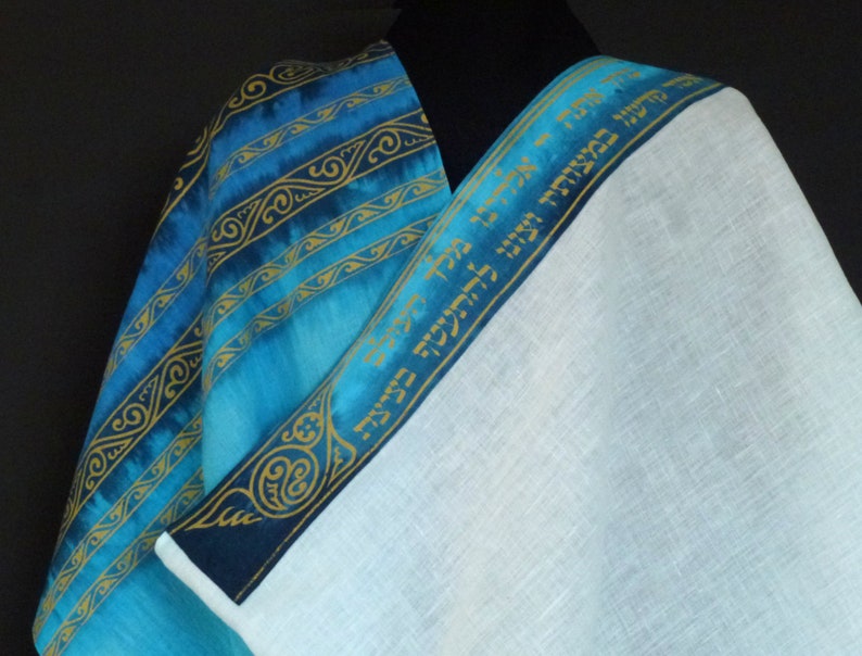 May include: A blue and white prayer shawl with gold Hebrew text on the border. The shawl is made of linen and has a blue and gold patterned design.