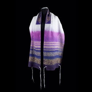 May include: A purple and white prayer shawl with gold embroidery and white fringes. The shawl is on a black background.