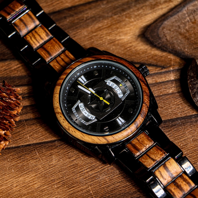 K&ouml;nnte beinhalten: Eine Holzarmbanduhr mit schwarzem Zifferblatt und Holzl&uuml;nette. Die Uhr hat ein schwarzes Metallarmband mit Holzakzenten. Die Zeiger der Uhr sind gelb. Die Uhr liegt auf einer Holzoberfl&auml;che.