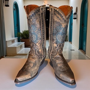 May include: A pair of distressed brown leather cowboy boots. The boots feature decorative stitching, silver-tone studs, and turquoise and silver embellishments. The interior is lined with a warm brown material.