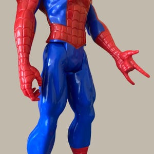 Puede incluir: Figura de acci&oacute;n de pl&aacute;stico de Spider-Man en una pose din&aacute;mica. La figura presenta una combinaci&oacute;n de colores rojo y azul, con brazos y pecho rojos, y piernas y torso azules. Las manos de la figura est&aacute;n en un gesto de lanzar telara&ntilde;as.