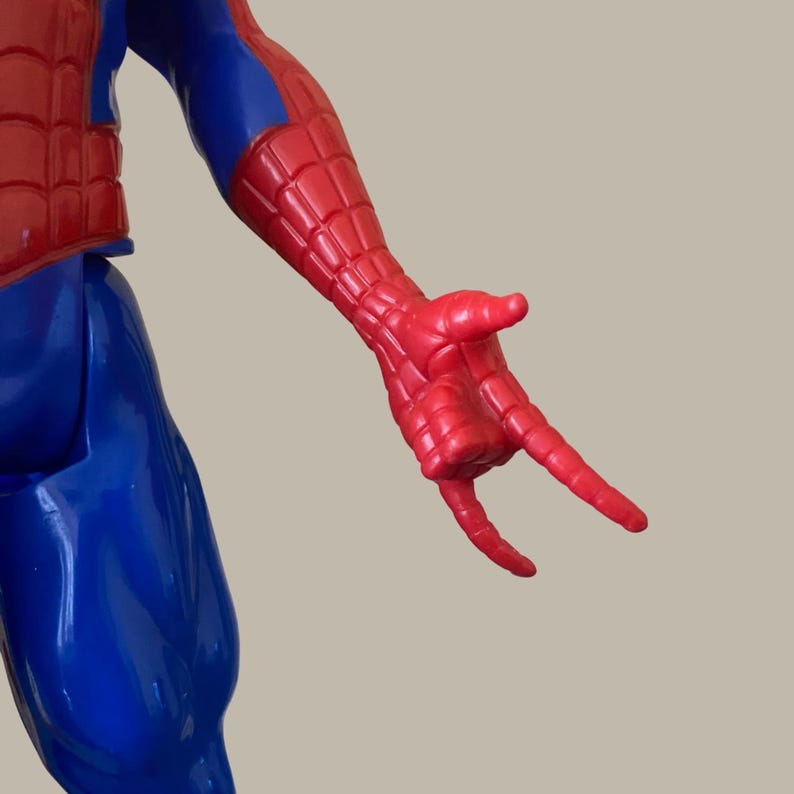 Puede incluir: Figura de acci&oacute;n de Spider-Man rojo y azul. El brazo de la figura est&aacute; extendido, con la mano en pose de lanzar telara&ntilde;as. El disfraz presenta un torso y brazos rojos, con piernas y detalles en azul.