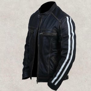 May include: Black leather jacket with white stripes on the sleeves. The jacket has a classic biker style with a zip-up front, a small collar, and a distressed finish. The jacket has a fitted silhouette.