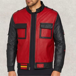 Puede incluir: Chaqueta de cuero roja y negra con cremallera, dos bolsillos cuadrados y mangas negras acolchadas. La chaqueta tiene dobladillo y puños de canalé y cuello negro. La chaqueta tiene un diseño retro.