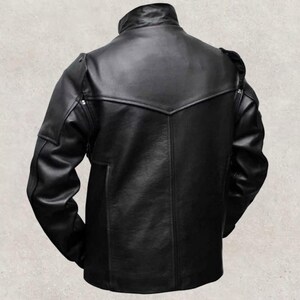 May include: A black leather jacket with a stand-up collar and a distinctive yoke design across the shoulders. The jacket has a tailored fit, long sleeves, and a subtle pocket detail on the lower front. The back view highlights the jacket's sleek, minimalist aesthetic.