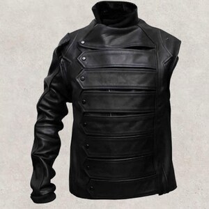 May include: Black leather jacket with a high collar and multiple horizontal bands across the chest. The jacket has one long sleeve and decorative button details, offering a unique, edgy style.