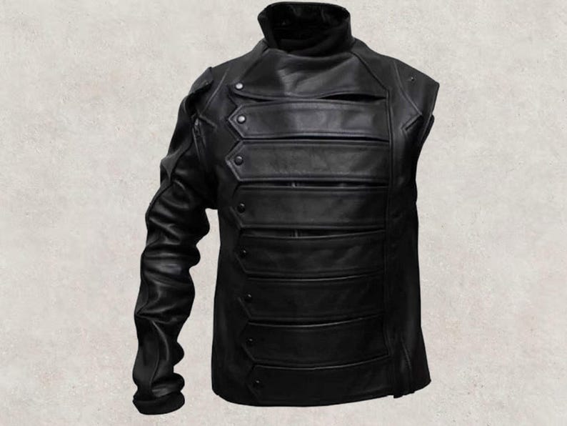 May include: Black leather jacket with a high collar and multiple horizontal bands across the chest. The jacket has one long sleeve and decorative button details, offering a unique, edgy style.