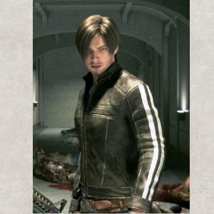 May include: A dark brown leather jacket with white stripes on the sleeves. The jacket has a classic design with a collar and a belt. The person in the image is wearing the jacket.