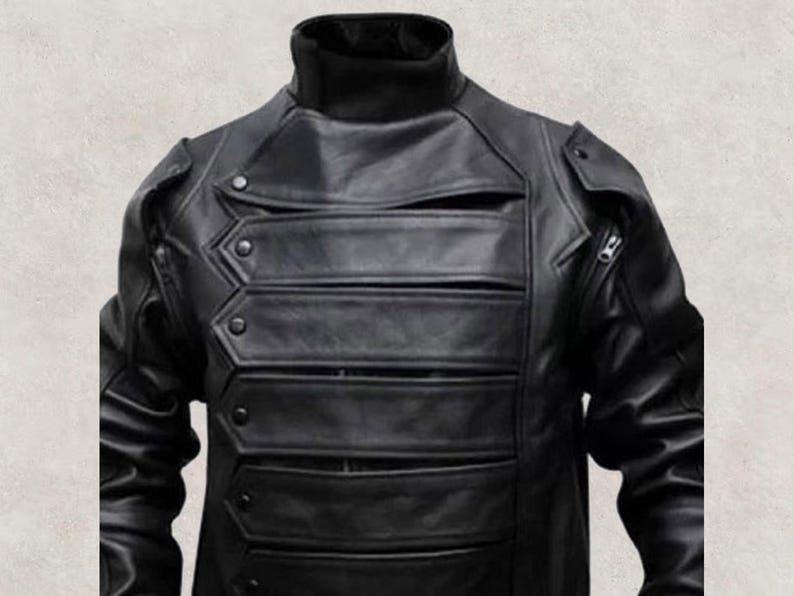 May include: A black leather jacket with a high collar and multiple horizontal chest pockets. The jacket features a unique design with decorative stitching and button details, and a zipper on the right side.