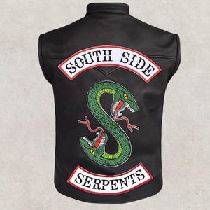 May include: Black leather vest featuring a green snake emblem with red accents. The vest has white patches with the words "SOUTH SIDE" and "SERPENTS" in red lettering. A sleeveless biker-style jacket.