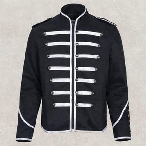 Puede incluir: Chaqueta negra con ribetes y detalles blancos. La chaqueta presenta un cuello alto, botones plateados y rayas blancas horizontales en el pecho. Las mangas tienen detalles plateados y botones en los puños. Un diseño elegante de inspiración militar.