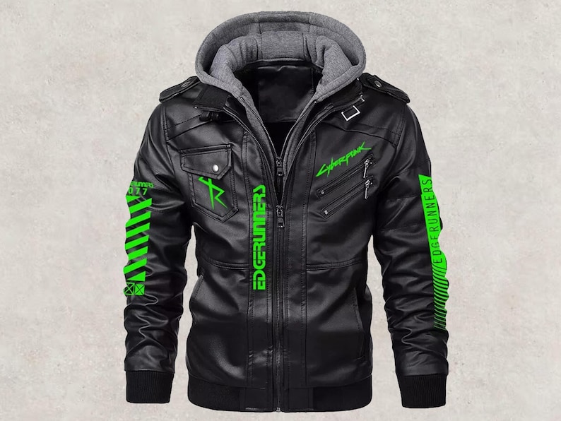 May include: Black faux leather jacket with a gray hooded insert. The jacket features green "Cyberpunk" and "Edgerunners" text and graphics. Includes two chest pockets, a zip closure, and a ribbed cuff.