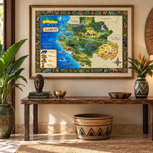 Op de afbeelding: Een ingelijste geïllustreerde kaart van Gabon met de nationale vlag, wilde dieren en geografische bezienswaardigheden. De kaart bevat tekstlabels voor steden, de Atlantische Oceaan en buurlanden, alles binnen een decoratieve rand van flora en fauna.