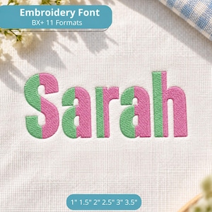 May include: The name Sarah is embroidered in a split-colour design of light green and pink on a white fabric background. The text Embroidery Font BX+ 11 Formats and the measurements 1 inch, 1.5 inches, 2 inches, 2.5 inches, 3 inches, 3.5 inches appear.