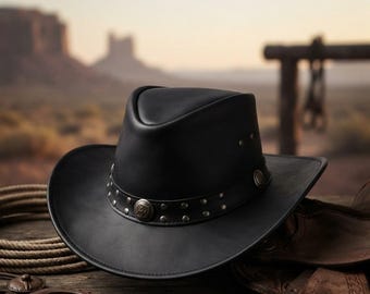 May include: A black leather cowboy hat featuring a structured crown and a wide, curved brim. The hat is accented with a black leather band adorned with small silver-toned metal studs and circular decorative conchos placed at intervals.