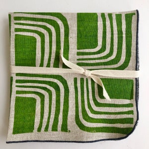 Pode incluir: Tecido de textura de linho com padr&atilde;o geom&eacute;trico verde e branco. O tecido est&aacute; dobrado e amarrado com uma fita branca.
