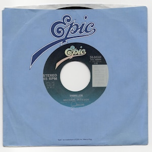 May include: A vintage 45 RPM vinyl record for Michael Jackson's song "Thriller" in a light blue paper sleeve. The record label is black and blue with the "Epic" logo and song details. The sleeve also features the "Epic" logo.