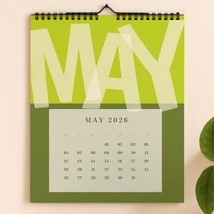 May include: A wall calendar for May 2026, featuring a bright green and olive green color scheme. The word "MAY" is prominently displayed in large, white, overlapping letters. The calendar grid shows the days of the month.