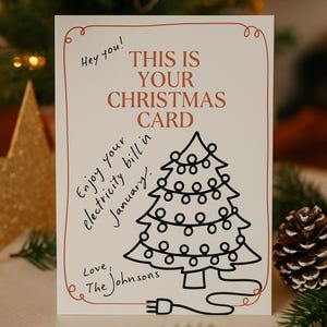 Op de afbeelding: Een kerstkaart met een rode rand en de tekst "THIS IS YOUR CHRISTMAS CARD". De kaart heeft een handgetekende kerstboom met lichtjes en een stekker. Extra tekst is "Hey you!" en "Enjoy your electricity bill in January."