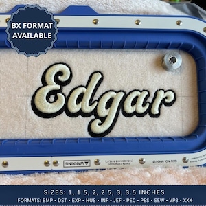 May include: An embroidery hoop with a blue plastic frame containing a white fabric piece featuring the name Edgar stitched in a cream-colored script font with a black outline. A badge states BX FORMAT AVAILABLE and text lists sizes 1 to 3.5 inches.