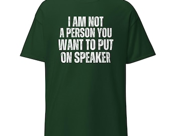 Op de afbeelding: Donkergroen t-shirt met de witte tekst "I AM NOT A PERSON YOU WANT TO PUT ON SPEAKER". Het shirt heeft korte mouwen en een ronde hals. De tekst staat in het midden op de voorkant van het shirt.