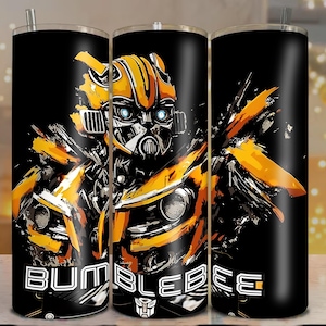 Puede incluir: Vaso negro con una vibrante ilustración de Bumblebee de Transformers. El diseño muestra al personaje en amarillo y negro, con la palabra "BUMBLEBEE" en blanco. Incluye una pajita.