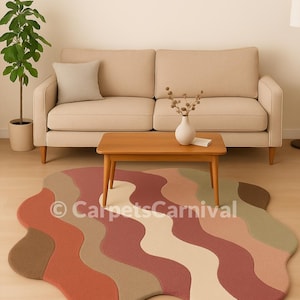 Op de afbeelding: Een kleurrijk vloerkleed met een golvend patroon in tinten rood, beige en bruin. Het kleed ligt in een woonkamer met een beige bank, een houten salontafel en een plant in een pot. De tekst "CarpetsCarnival" is zichtbaar.