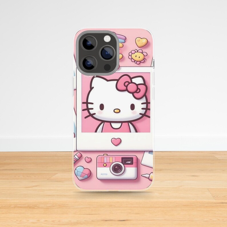 May include: Pink phone case featuring a Hello Kitty design. The case includes a polaroid-style image of Hello Kitty, along with other cute illustrations like hearts, flowers, and a camera. The case is designed for a smartphone.