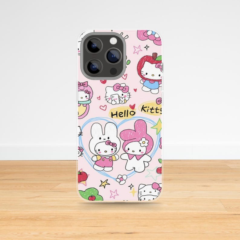 May include: Pink phone case featuring a repeating pattern of Hello Kitty and My Melody characters, apples, hearts, and stars. The words "Hello Kitty!" are also visible. The case has a silver camera lens.
