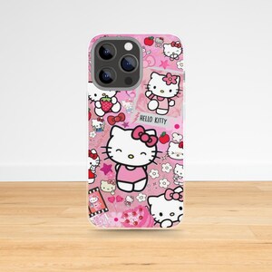May include: Pink phone case featuring a collage of Hello Kitty illustrations, stars, and flowers. The case has a glossy finish and includes the text "Hello Kitty". The design incorporates various poses of the iconic character.