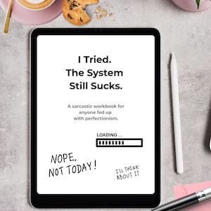 Könnte beinhalten: Ein digitales Tablet zeigt den Text "I Tried. The System Still Sucks." mit Sätzen wie "Nope, Not Today!" und "I'll Think About It." Es bewirbt ein sarkastisches Arbeitsbuch für alle, die Perfektionismus satt haben. Eine Tasse Kaffee und ein Keks sind im Hintergrund.