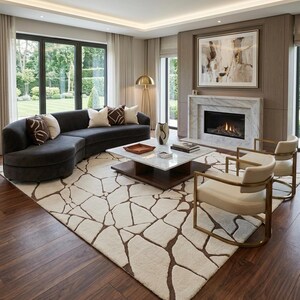 ​Rectangular handtufted wool area rug featuring an organic cracked earth mosaic pattern in earthy brown on a cream base for modern minimalist decor.