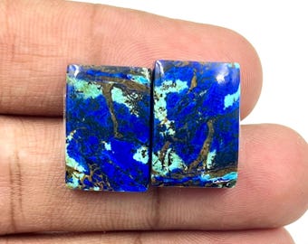 May include: Two rectangular gemstones with a vibrant blue hue, accented by streaks of teal and brown. The polished stones have a glossy finish, showcasing natural patterns. These gemstones are ideal for jewelry making.