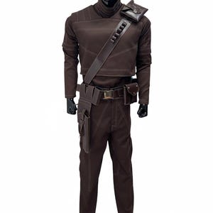 May include: A brown costume with white stitching, displayed on a mannequin. The outfit includes a long-sleeved top, pants, a belt with pouches, and a shoulder strap with a pouch. The mannequin has a black head and hands.