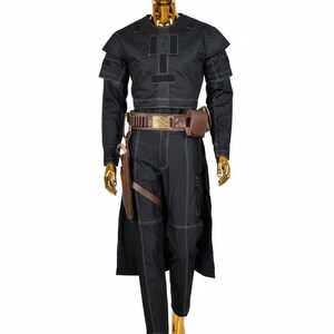 May include: Black costume with white stitching, displayed on a gold mannequin. The outfit includes a long-sleeved top, pants, and a belt with a pouch. A holster and a long coat complete the ensemble. The costume is designed with a futuristic aesthetic.